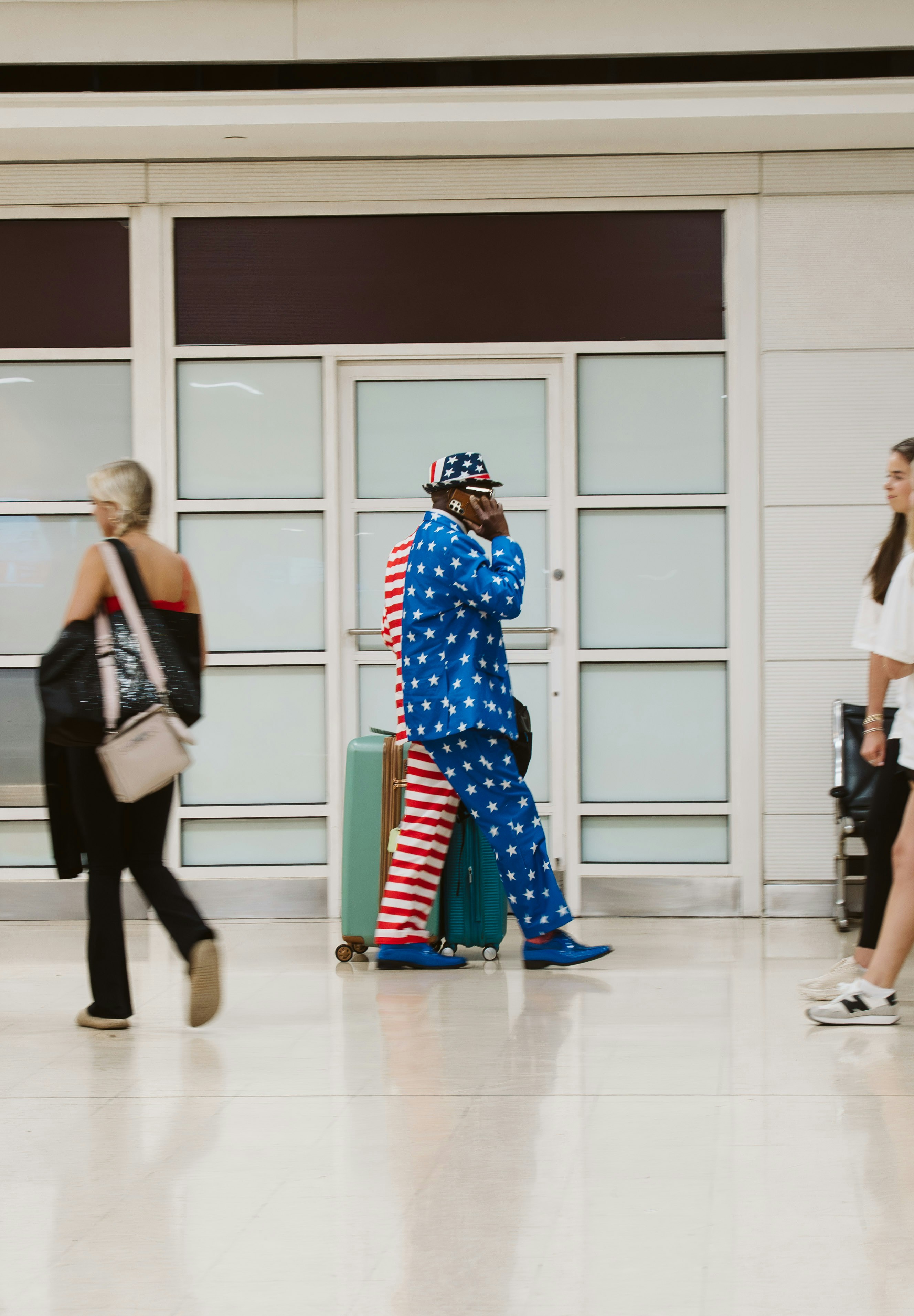 Man in star suit talks on phone in airport