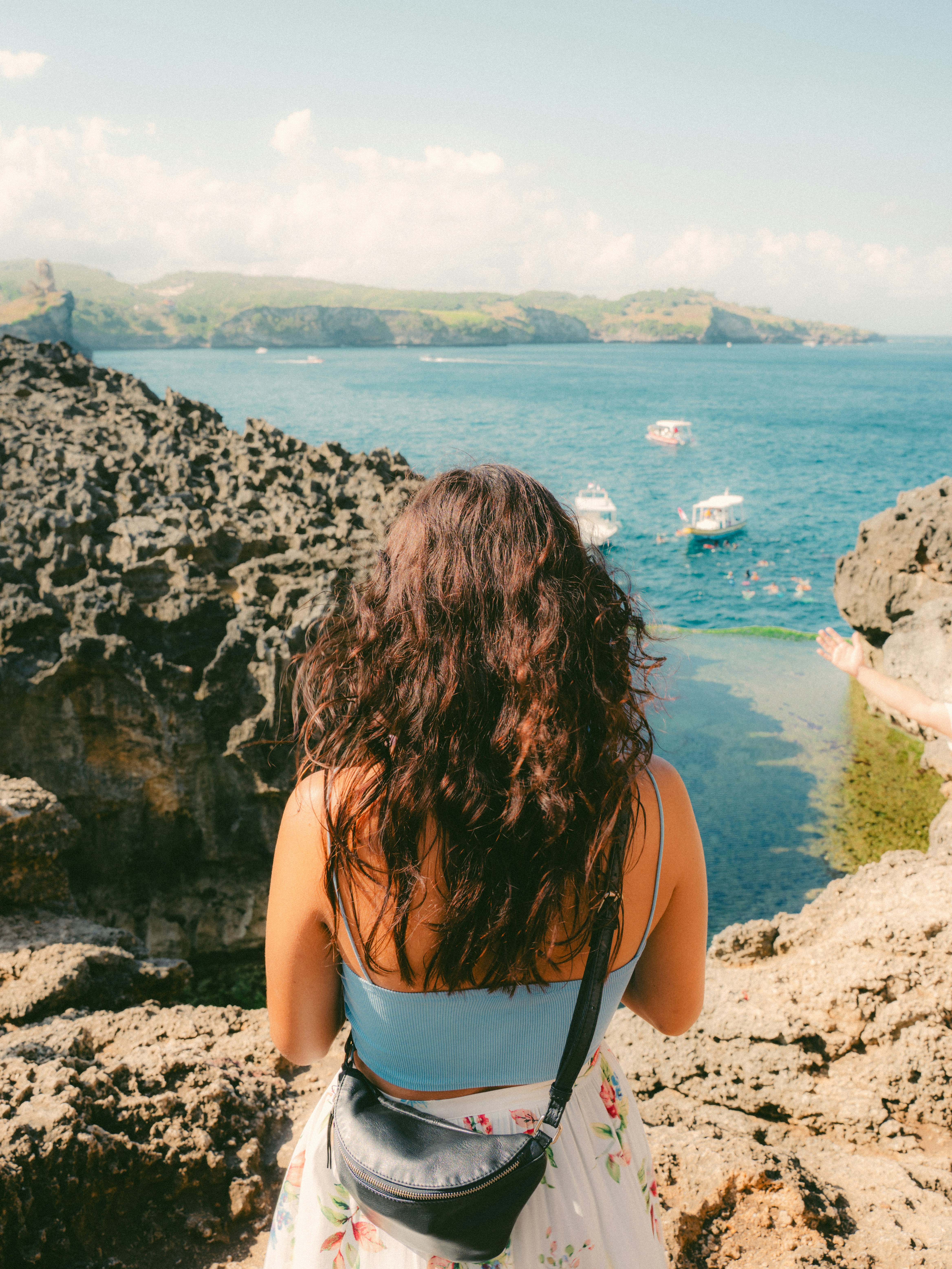 Woman looking at a scenic coastal view with boats