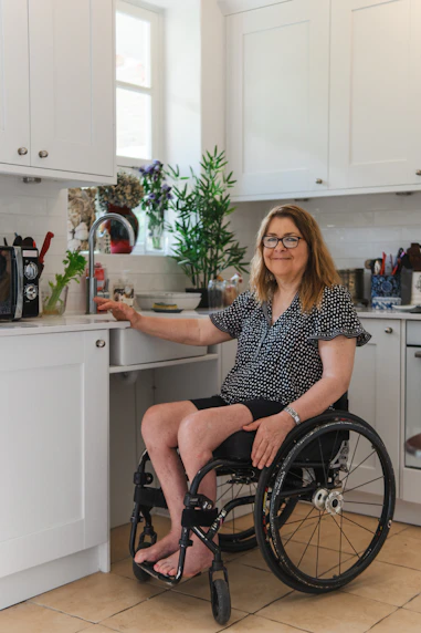 Woman in wheelchair using kitchen sink