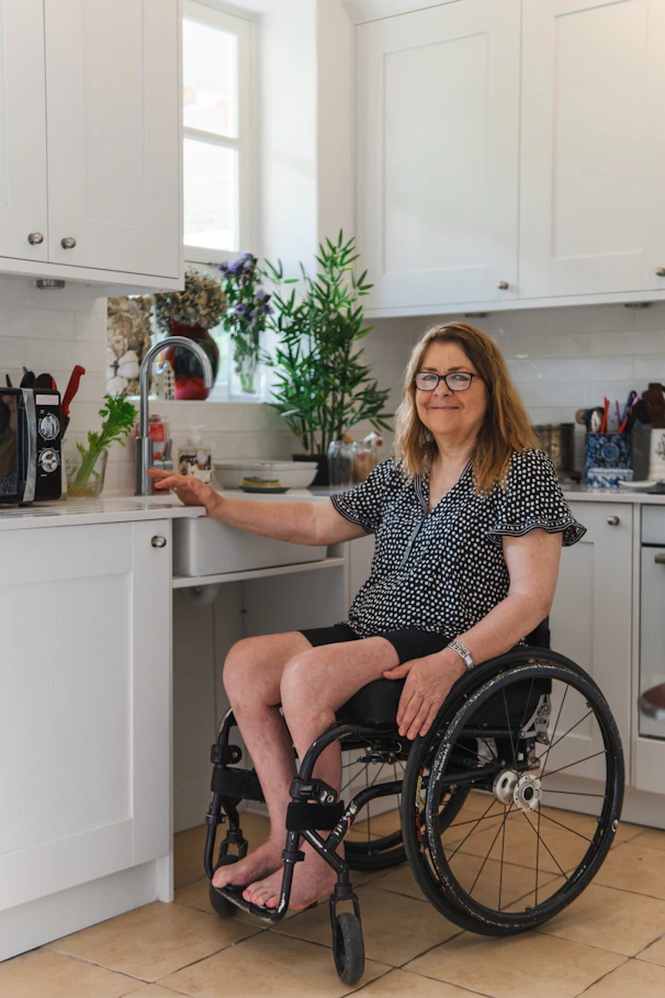 Woman in wheelchair using kitchen sink