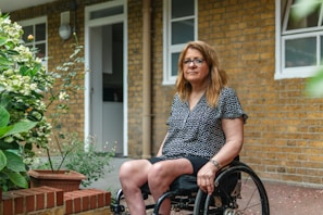 Woman in wheelchair outside brick building