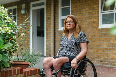 Woman in wheelchair outside brick building