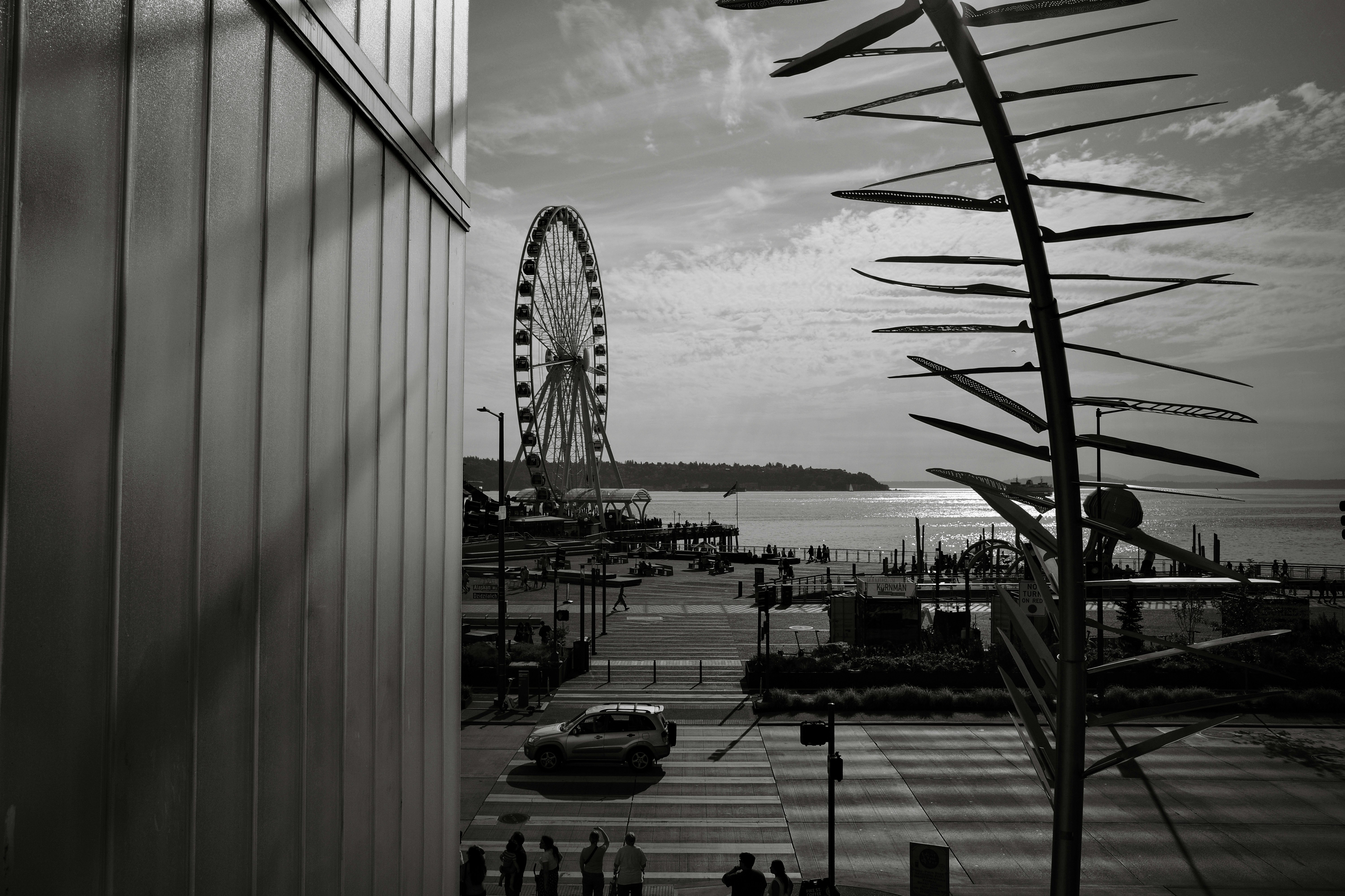 Ferris wheel by the water with cityscape elements of city buildings