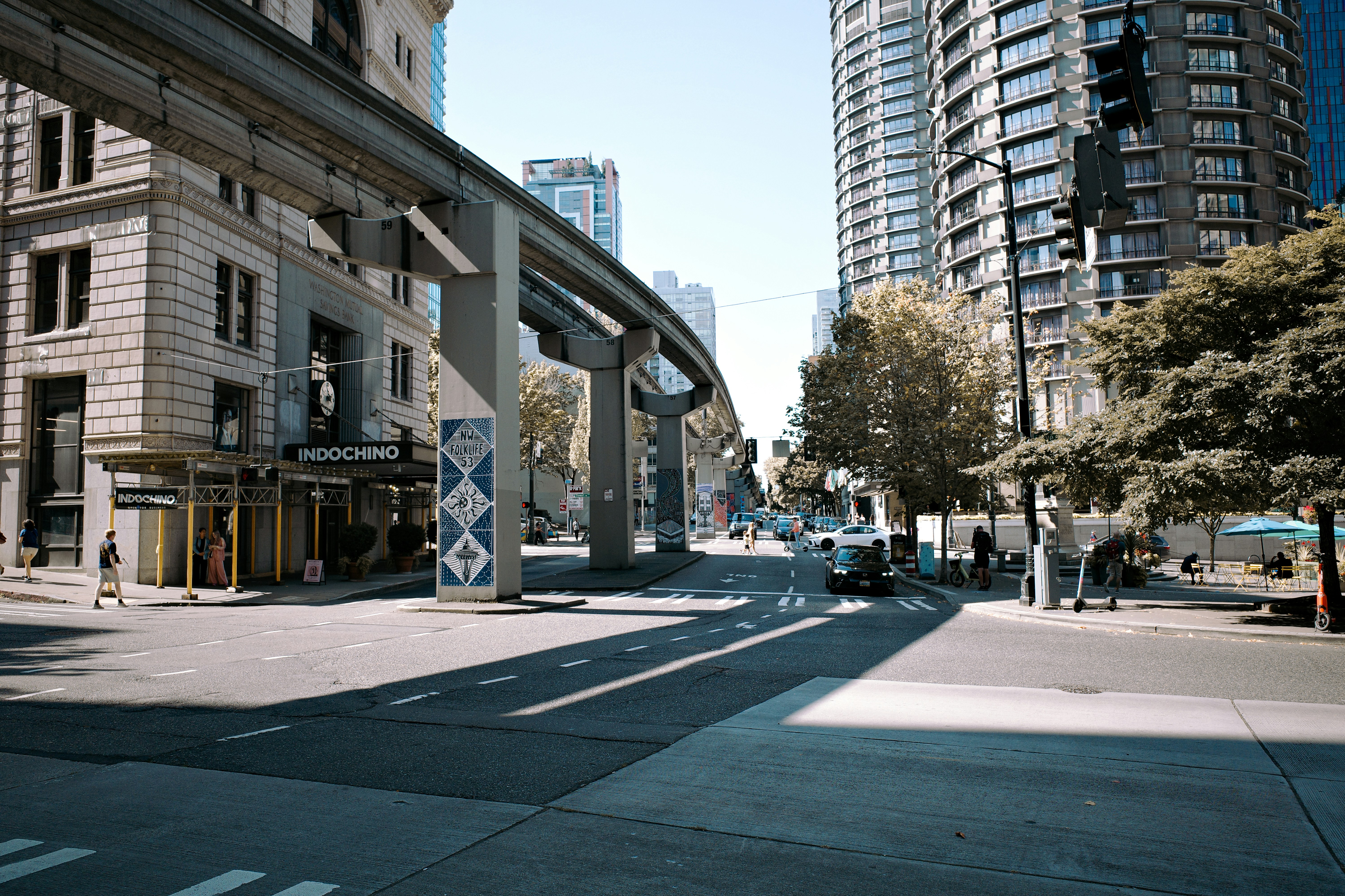 Monorail track above a city street with buildings.