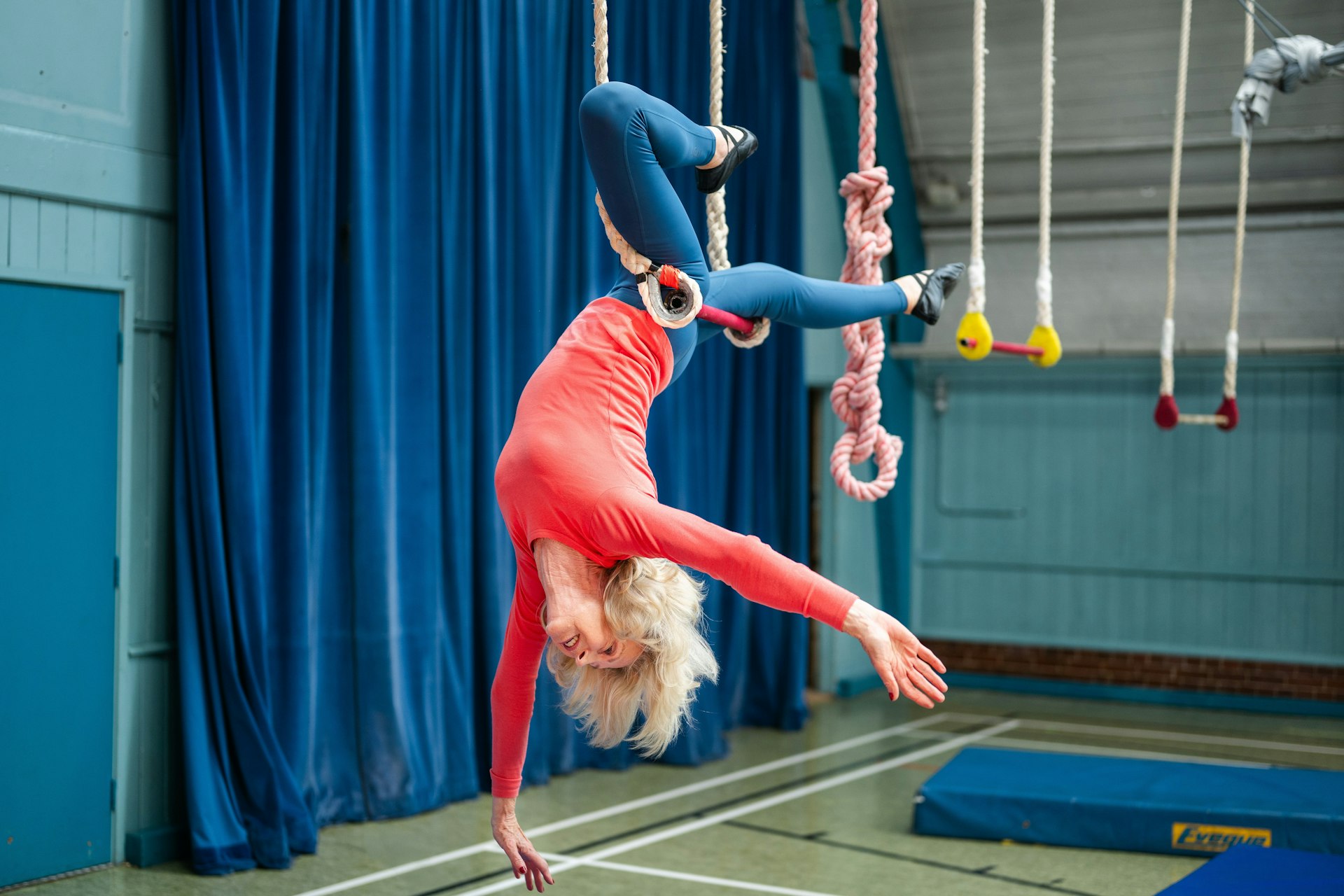 Woman performing aerial acrobatics on trapeze rings