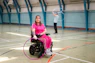 Woman in wheelchair with hula hoop, man in background