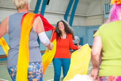 Dancers moving with flowing fabric in a dance fitness class