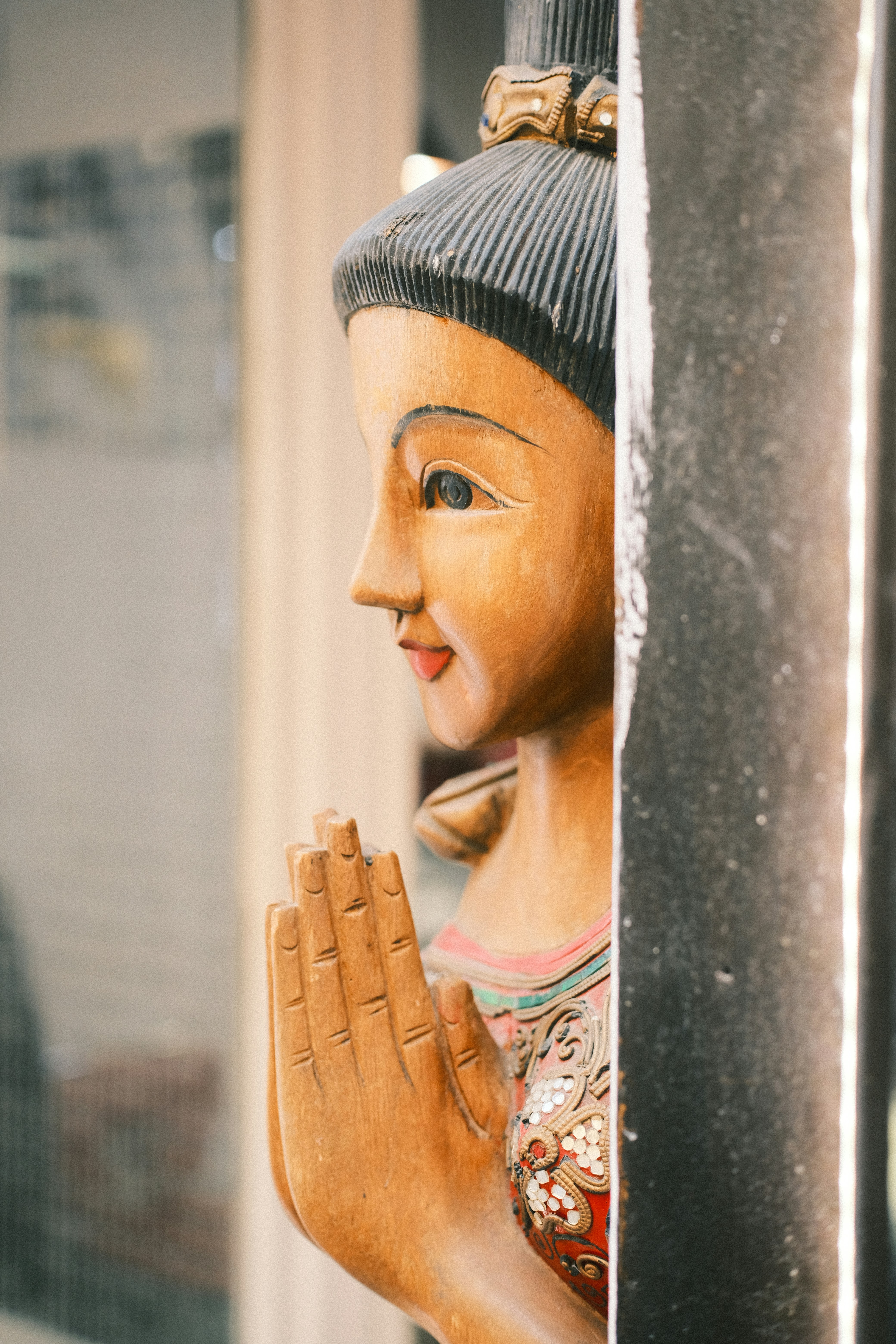 Wooden statue of a woman with hands clasped