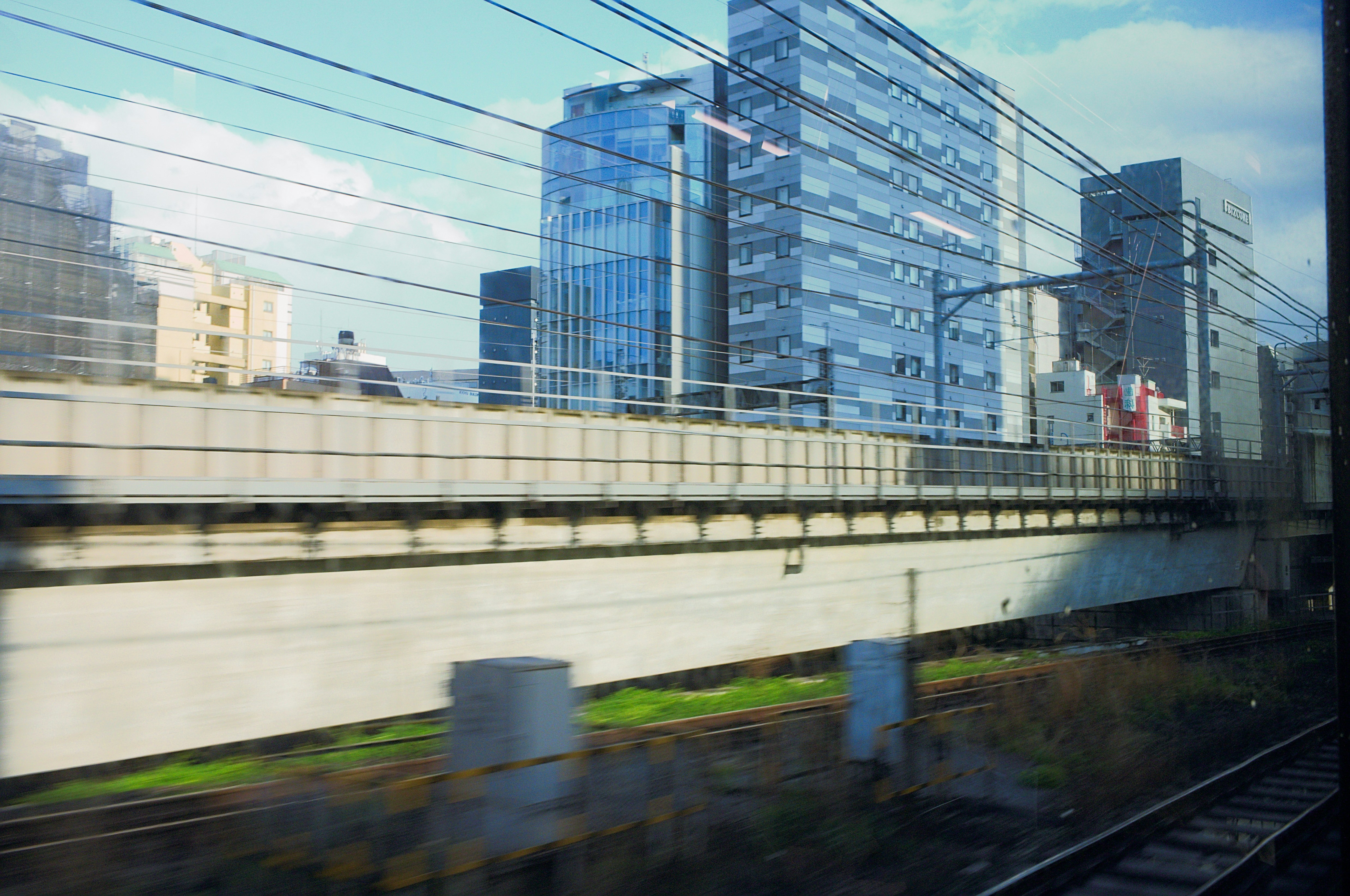 Edificios modernos de la ciudad vistos desde un tren en movimiento.