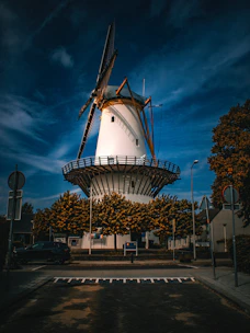White windmill with large blades against a dark sky