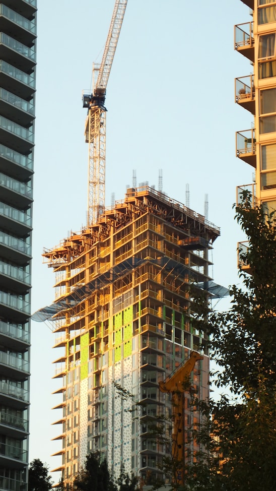 Skyscraper construction with crane against clear sky