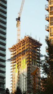 Skyscraper construction with crane against clear sky