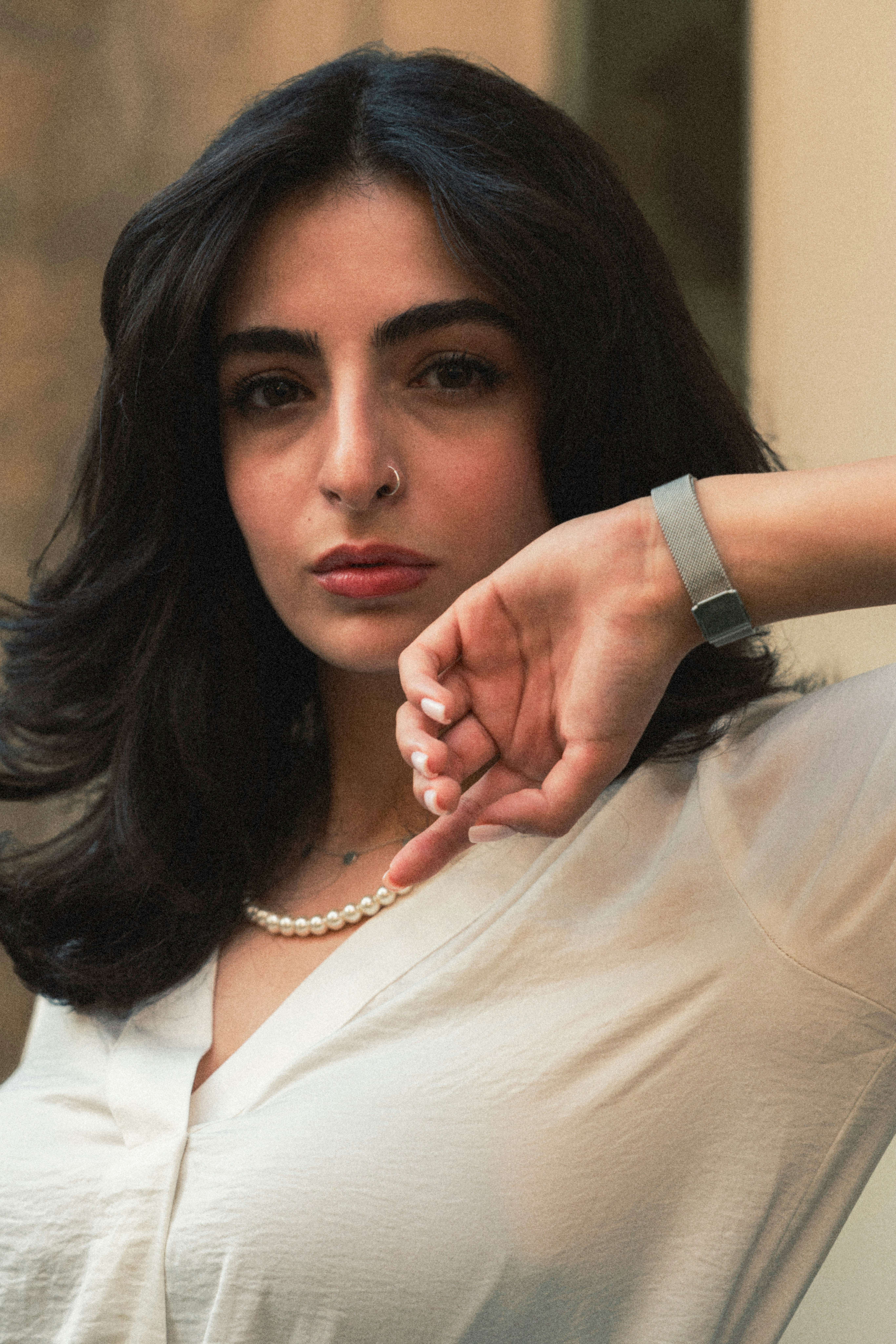 Woman with dark hair wearing a pearl necklace