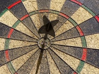 A dart hitting the bullseye on a dartboard.