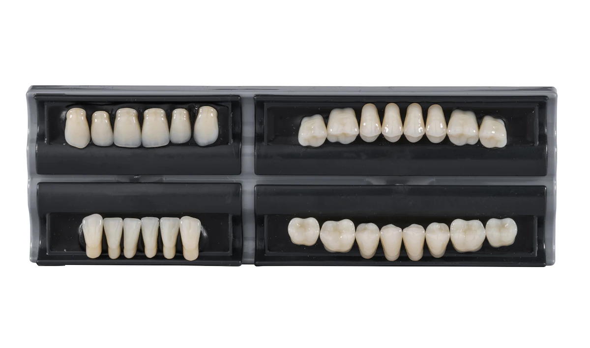 İllüstratif görsel: Four sets of artificial teeth in black cases.