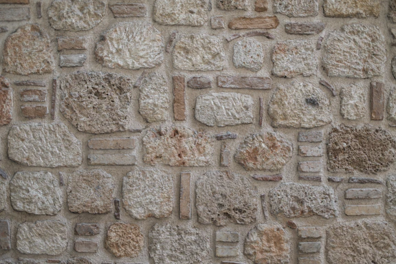 Rough textured stone wall with varied stones and irregular blocks
