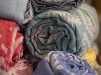 Rolled towels with colorful patterns stacked together.