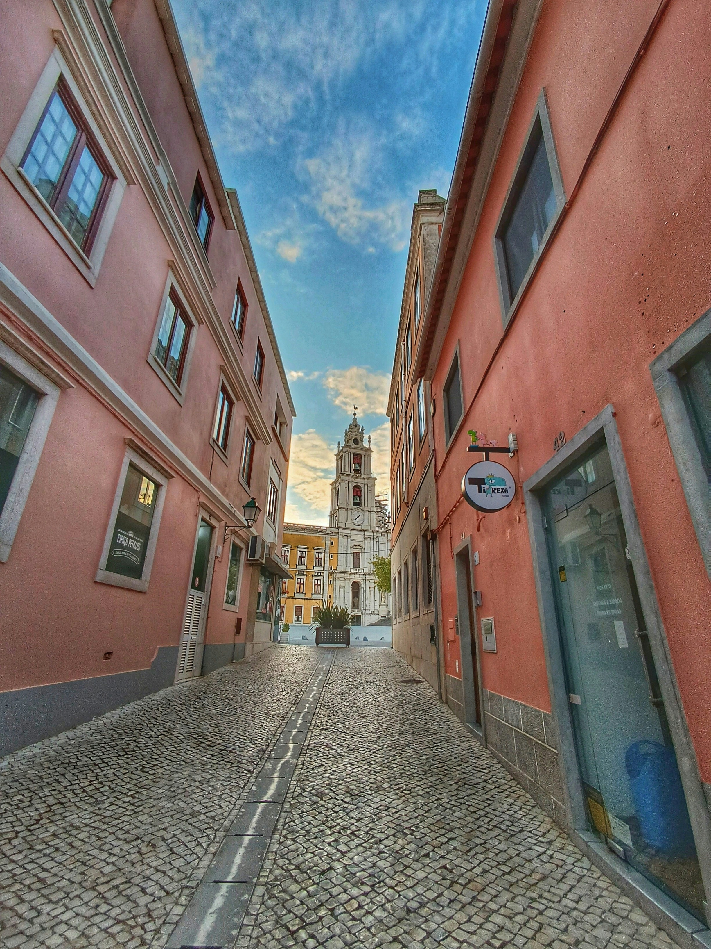 Calle empedrada que conduce a la torre de una iglesia