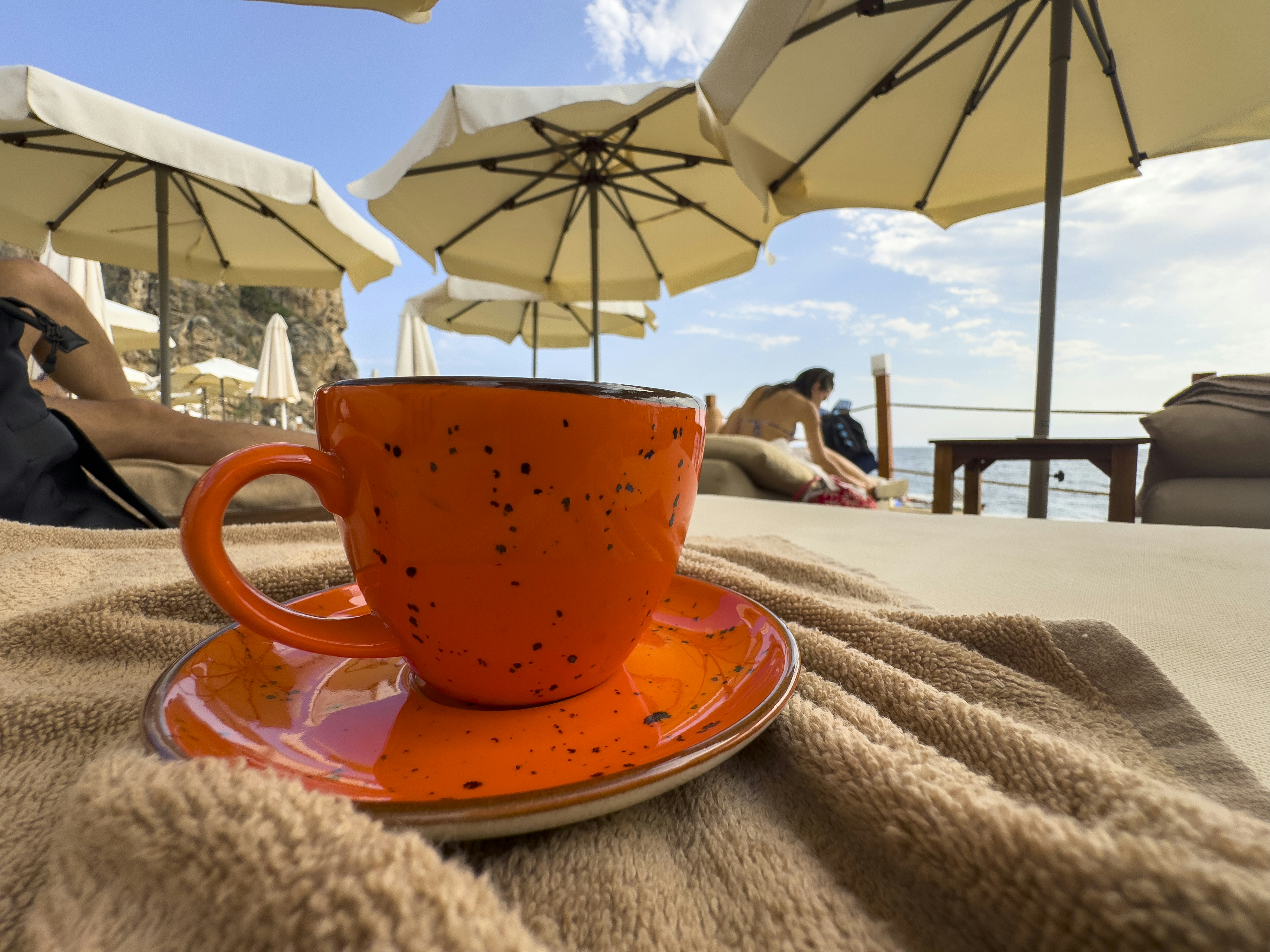 Orange coffee cup on a towel at the beach. photo  Free Beach Image on  Unsplash