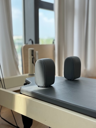 Pilates reformer with padded headrest and foot rests.