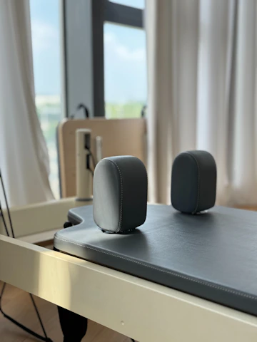 Pilates reformer with padded headrest and foot rests.
