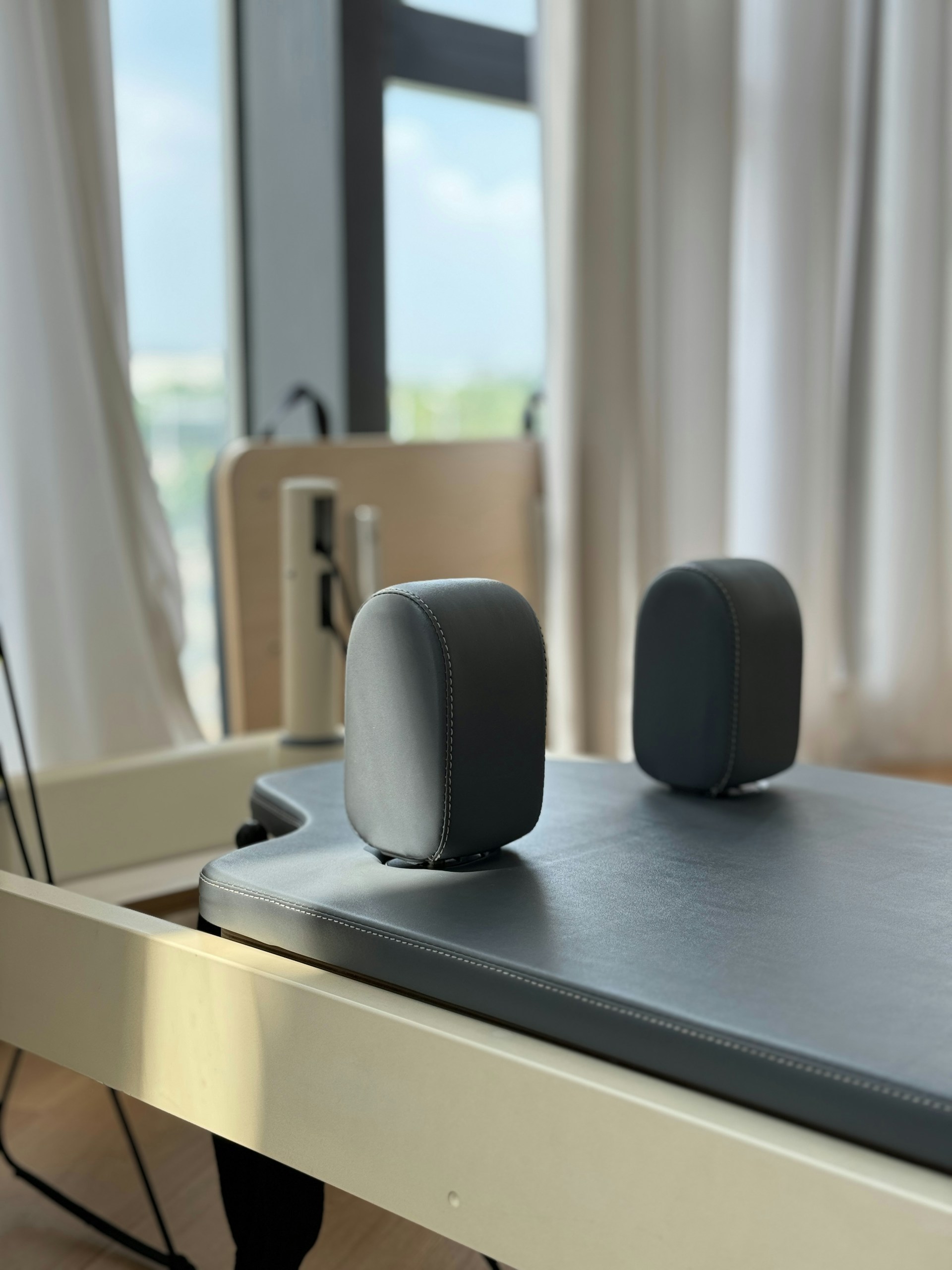 Pilates reformer with padded headrest and foot rests.