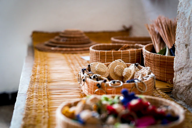 Woven baskets and hats displayed on a textured surface.