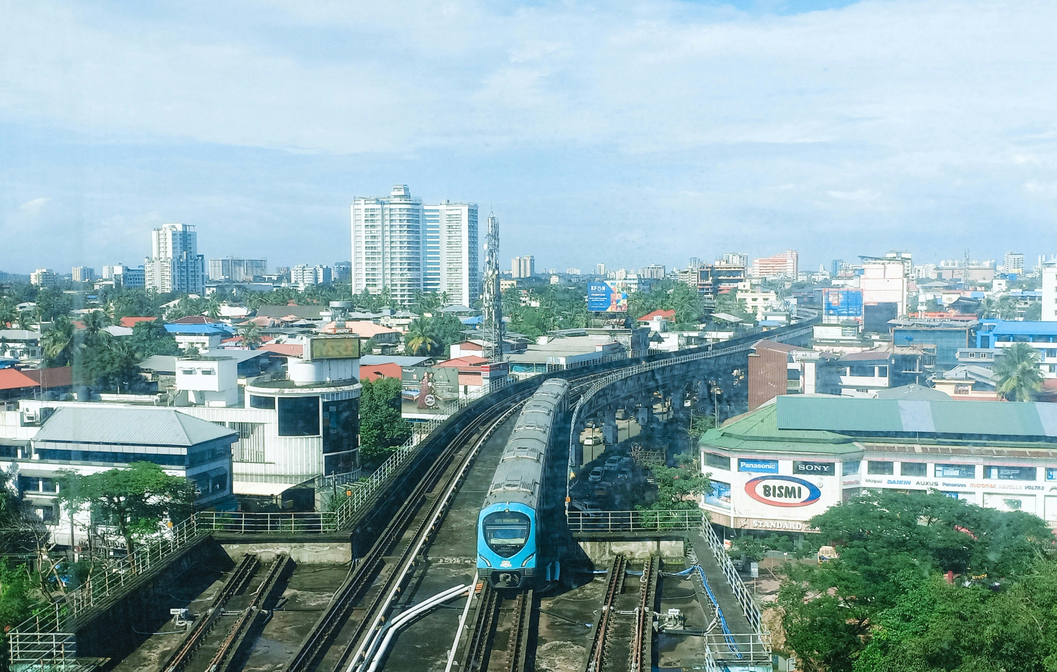 Modern train travels on elevated tracks through city.