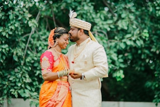 A bride and groom share a tender moment outdoors.