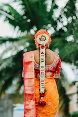 Bride with elaborate floral hairstyle and orange saree