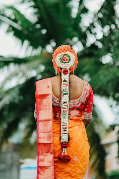 Bride with elaborate floral hairstyle and orange saree