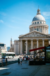 People walk past the pantheon building in paris.