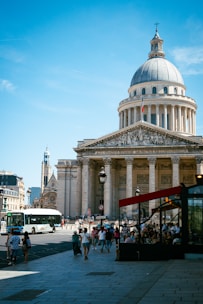 People walk past the pantheon building in paris.
