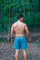 Man with muscular back in forest
