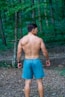 Man with muscular back in forest