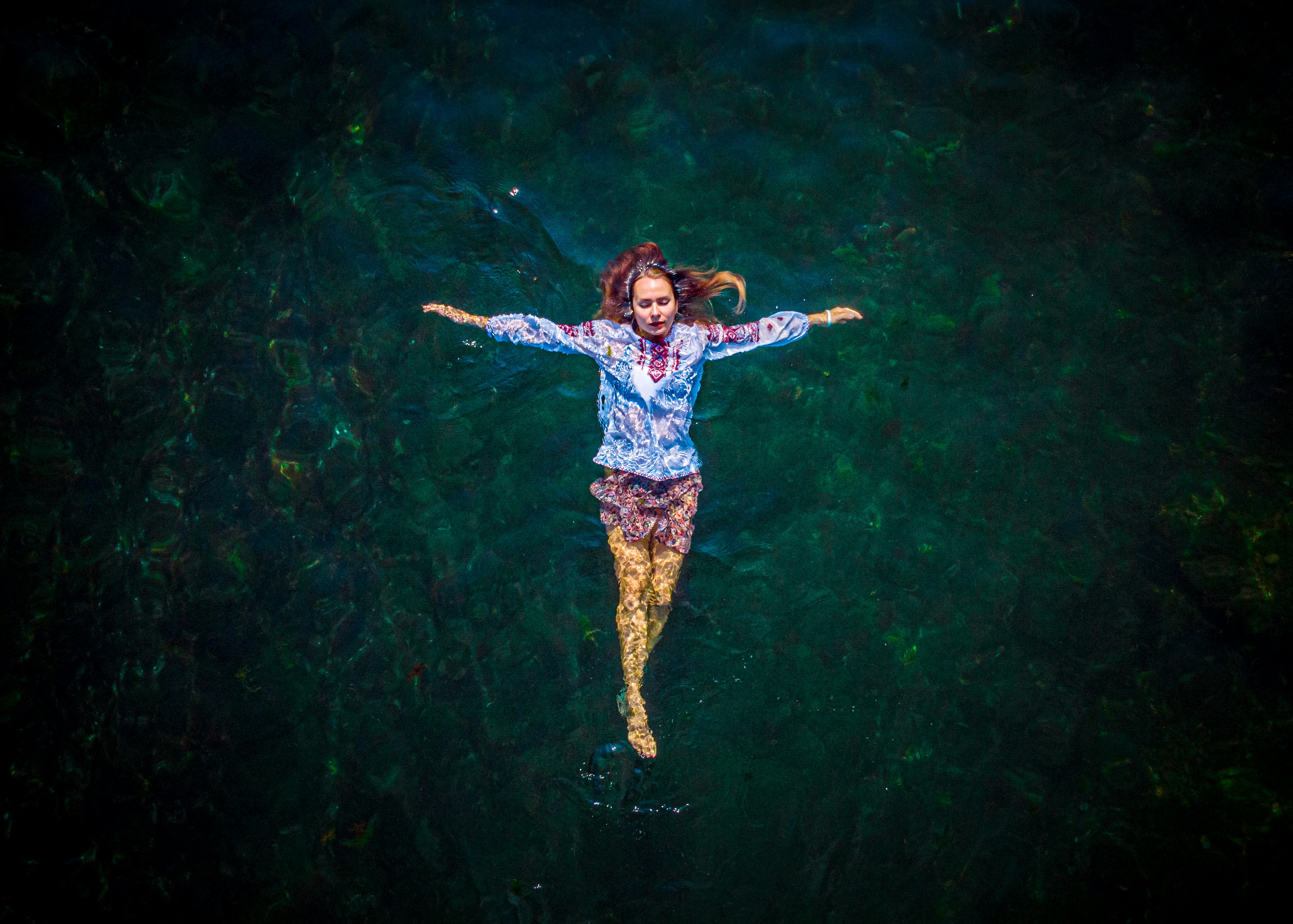 Woman floating on her back in dark water
