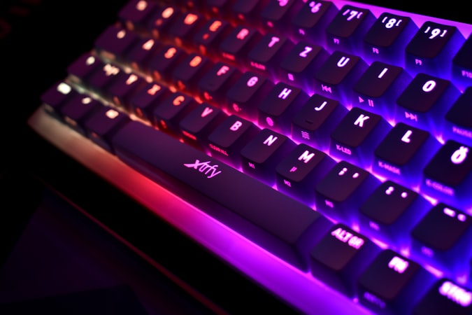 Close-up of a backlit keyboard with purple and pink lighting showing individual key switches