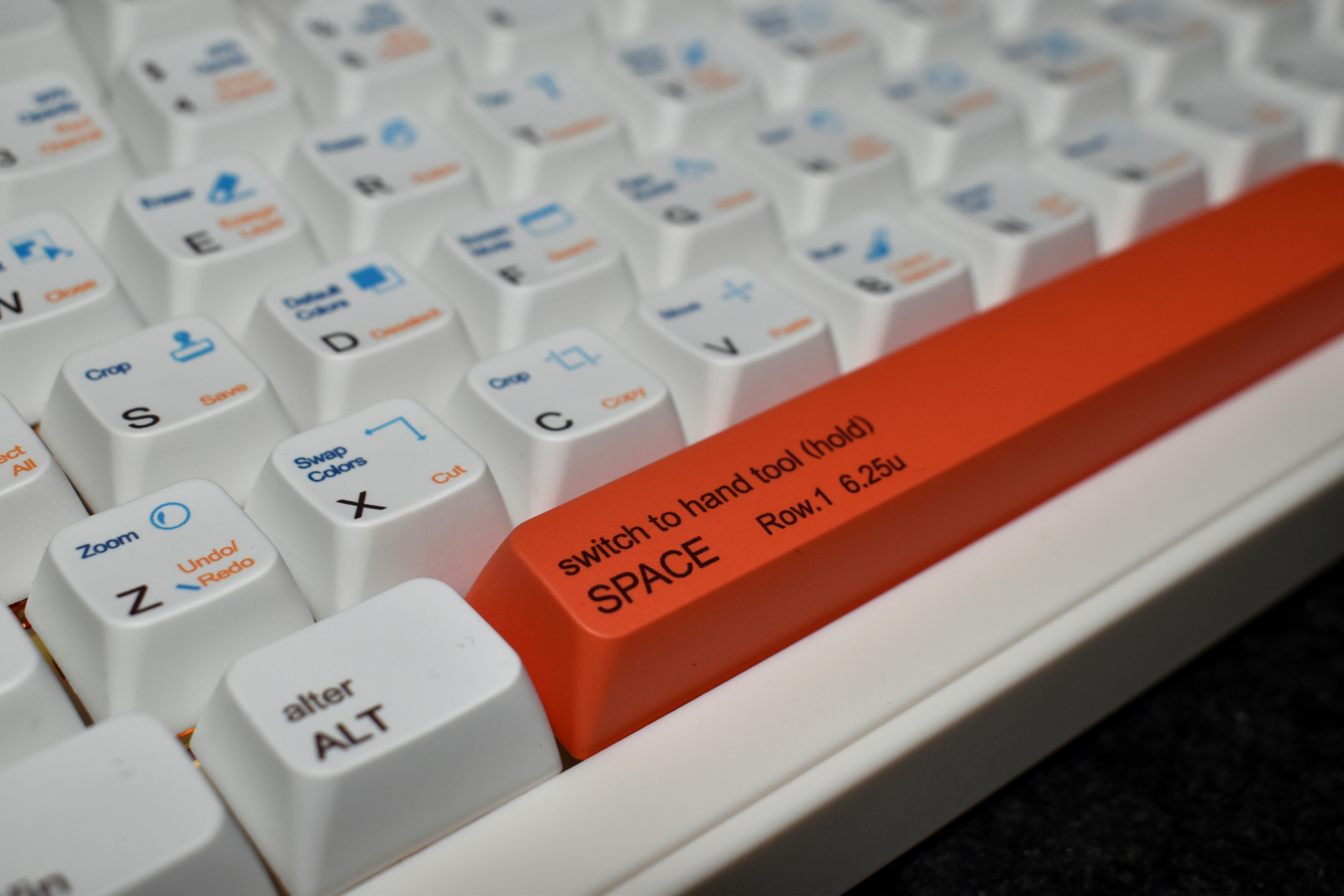 Close-up of a white keyboard with an orange space bar