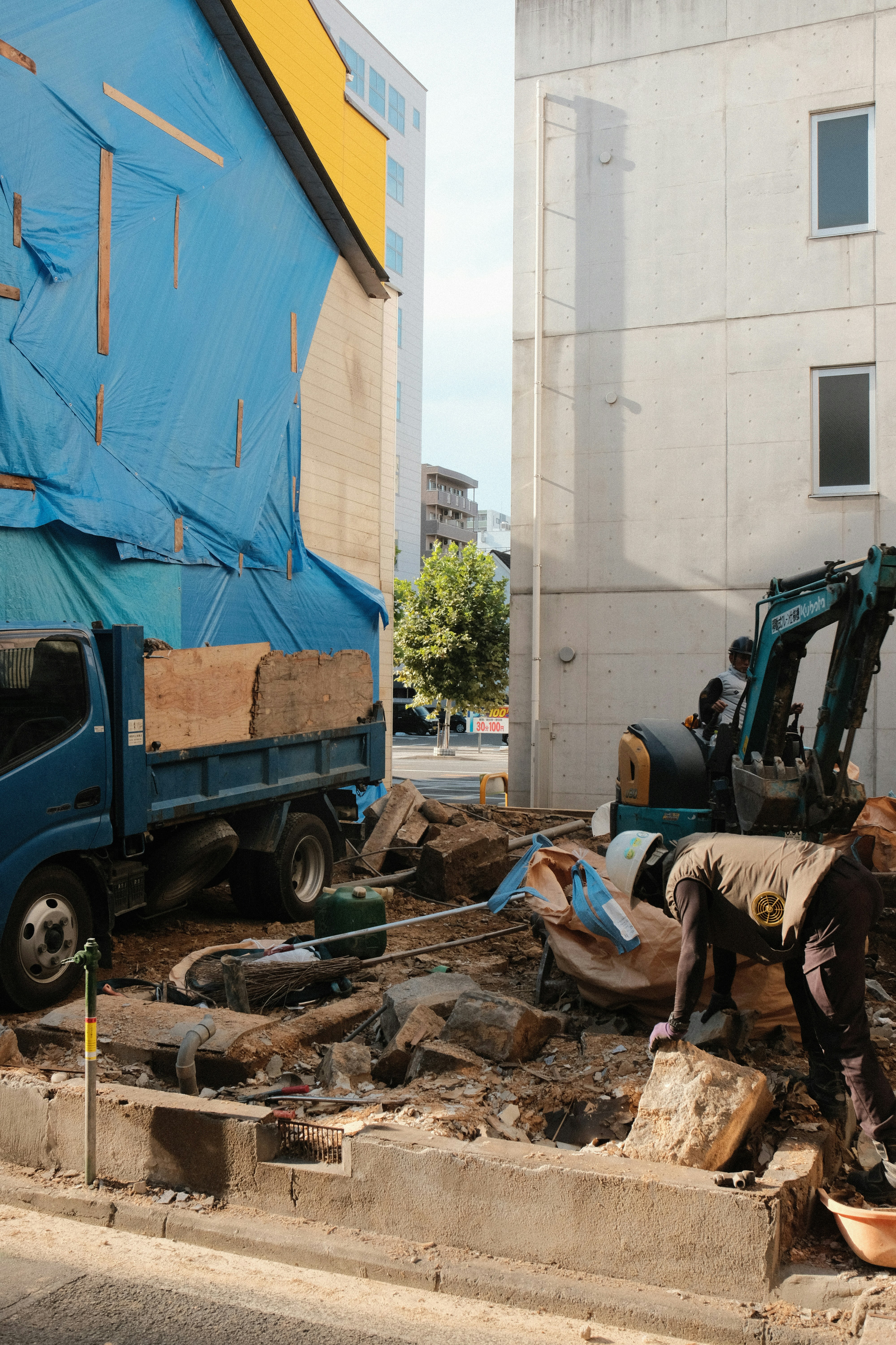 Pekerja konstruksi dan excavator di lokasi proyek bangunan