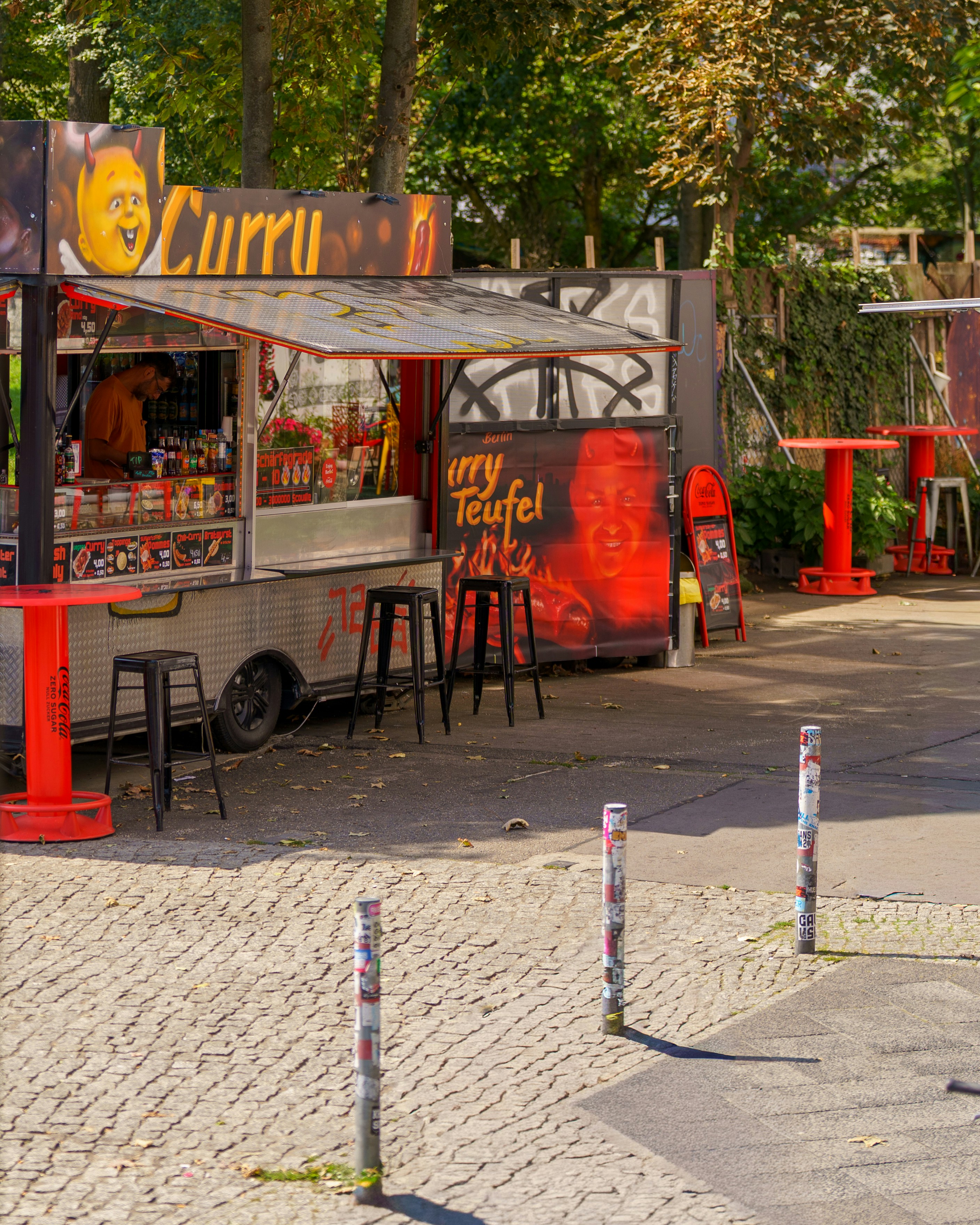 Um caminhão de comida com mesas vermelhas e bancos do lado de fora