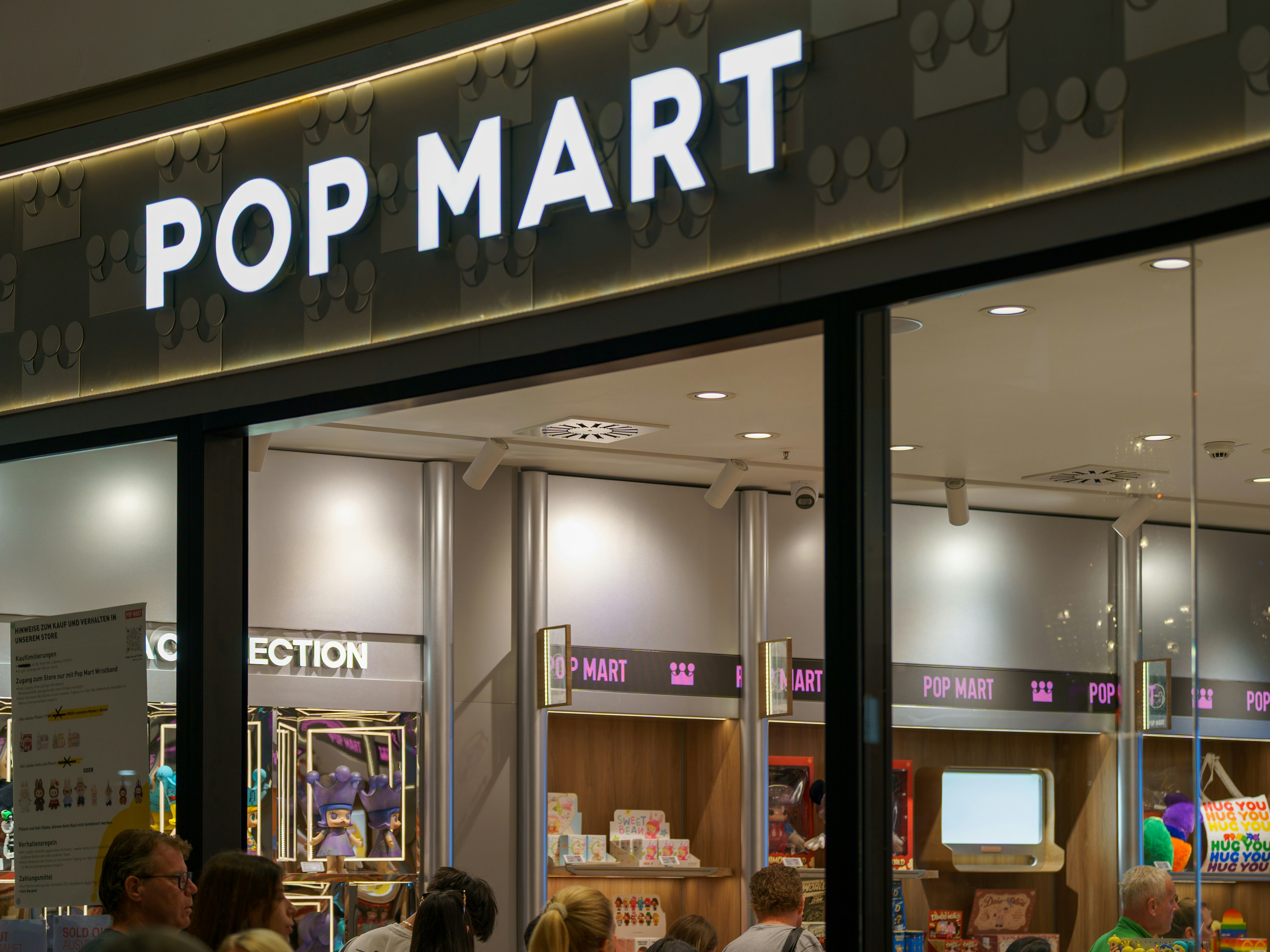 Pop mart store entrance with illuminated sign and displays