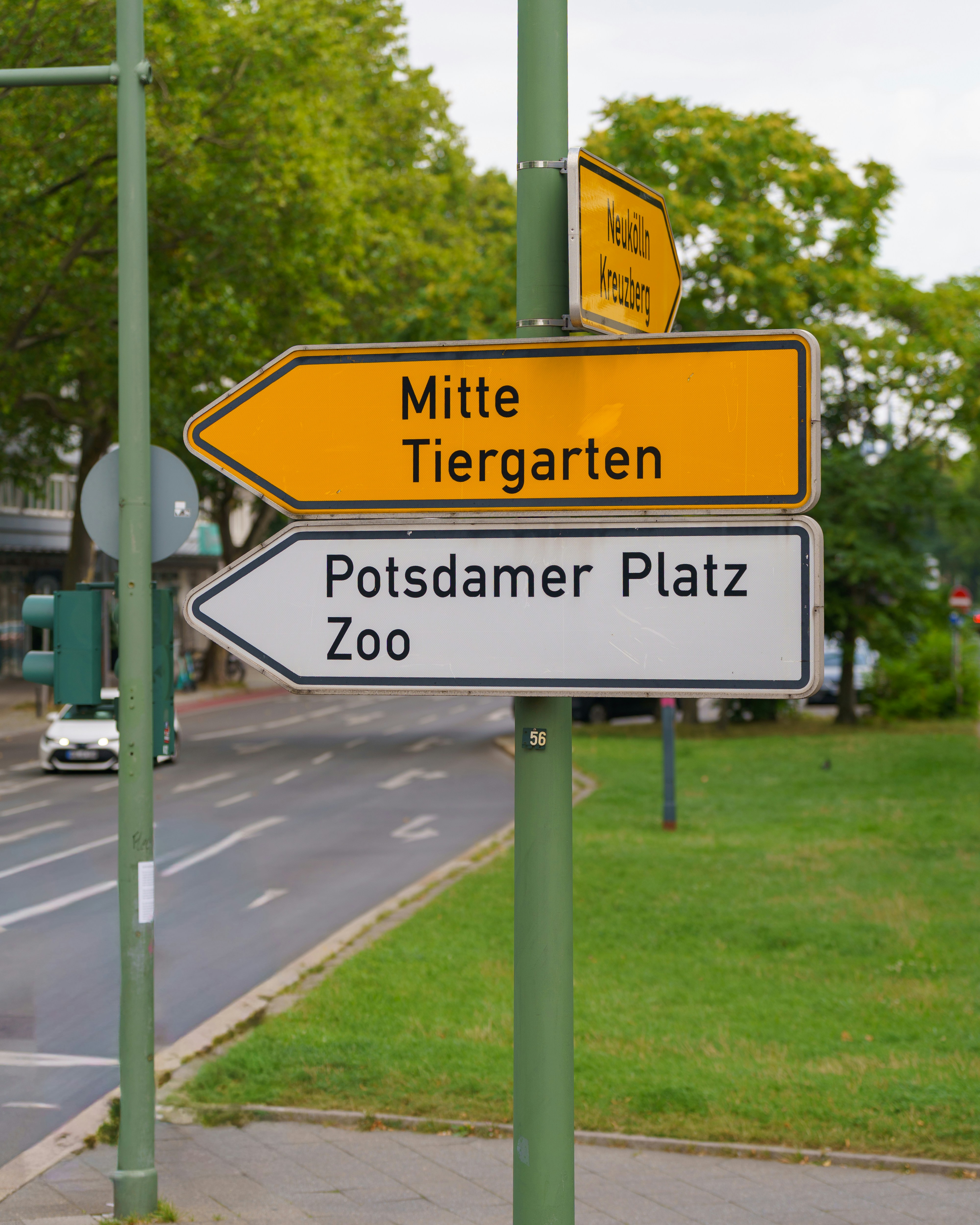 Street signs point towards mitte, tiergarten, potsdamer platz, and zoo.