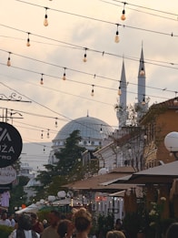Street with hanging lights and a mosque in the background