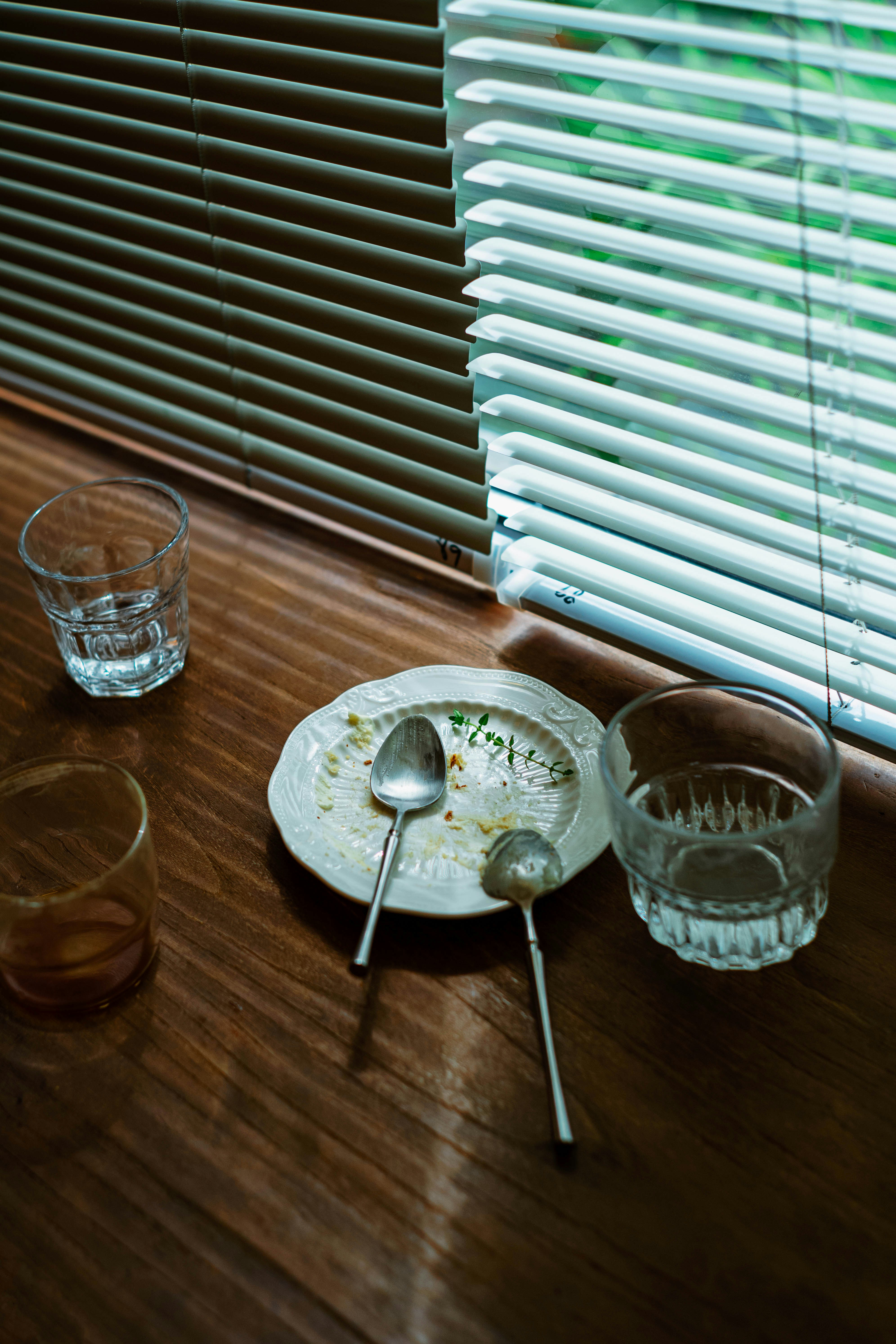 Pratos sujos e copos em uma mesa de madeira.