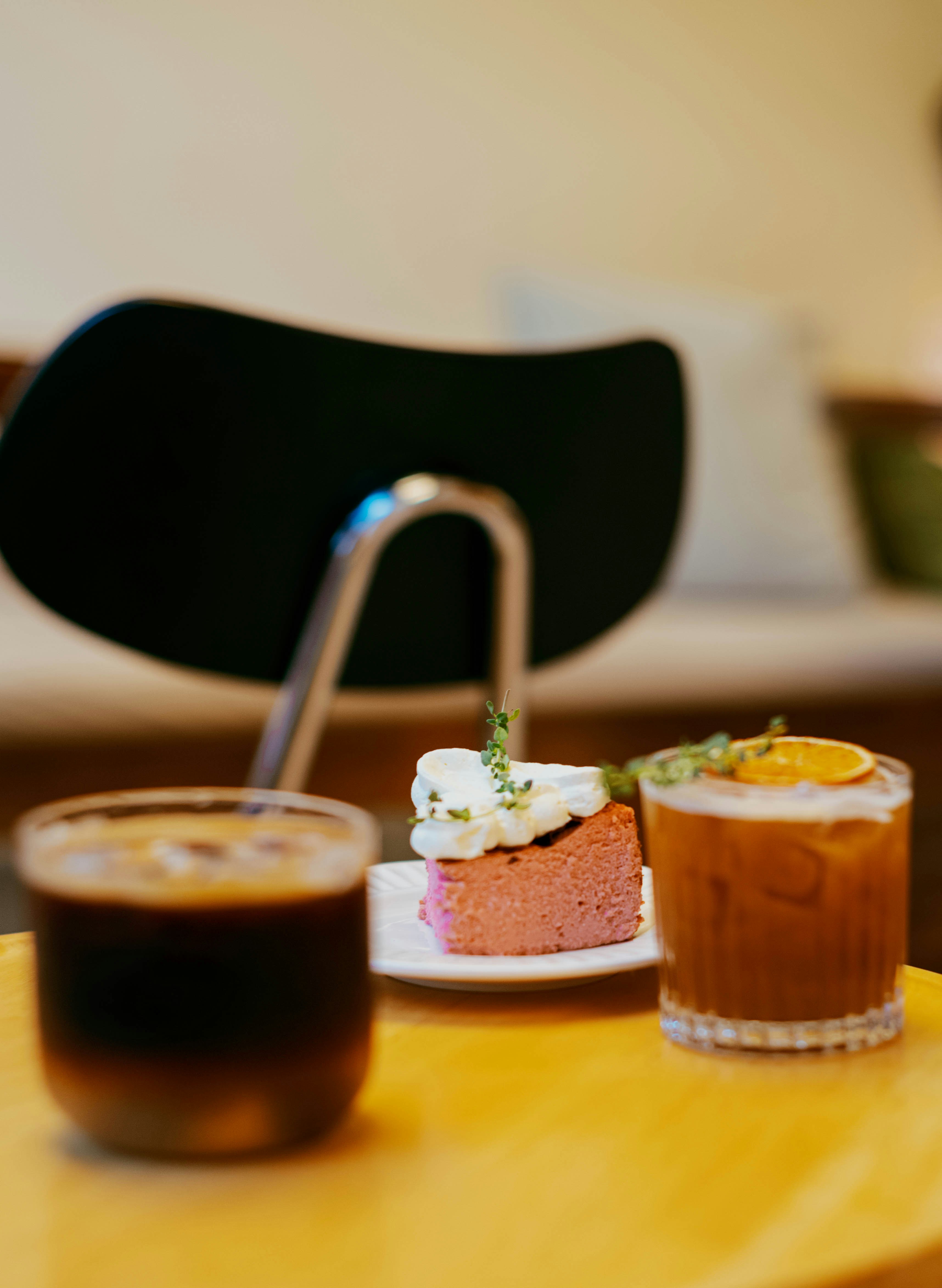 Dois cafés gelados e uma fatia de bolo rosa.