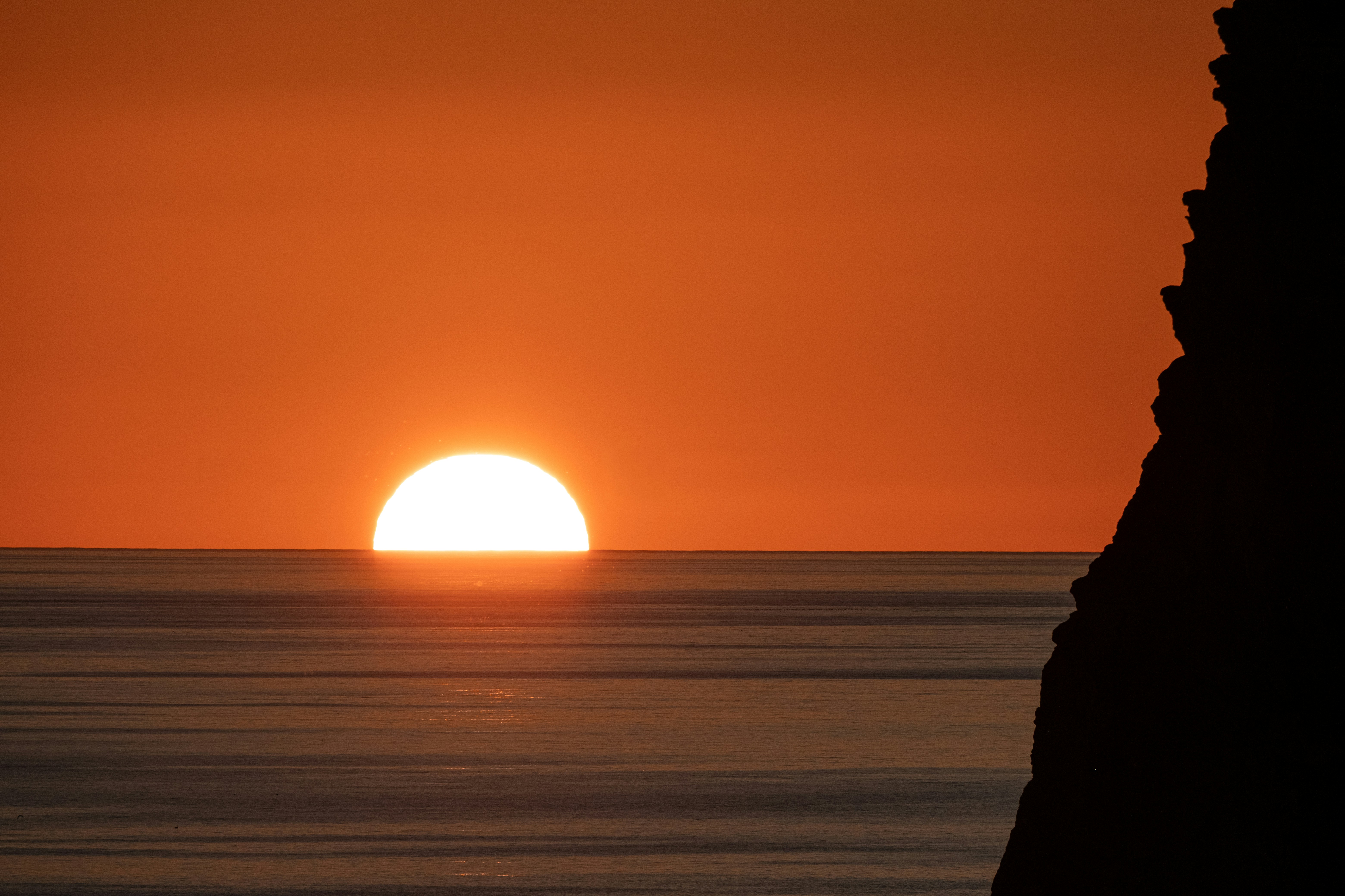 절벽이 있는 바다 너머로 지는 일몰