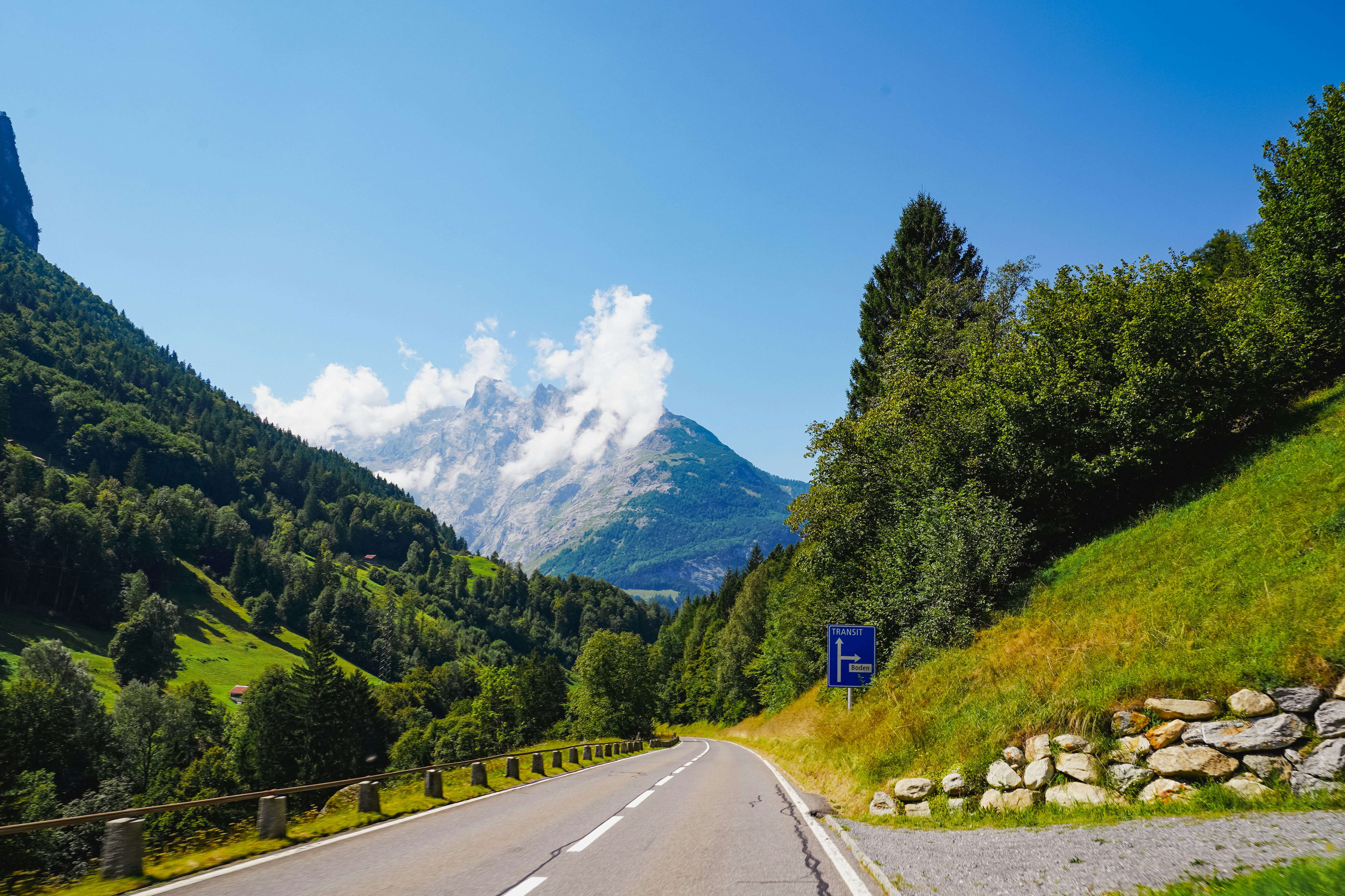 Winding road through a lush green mountain valley