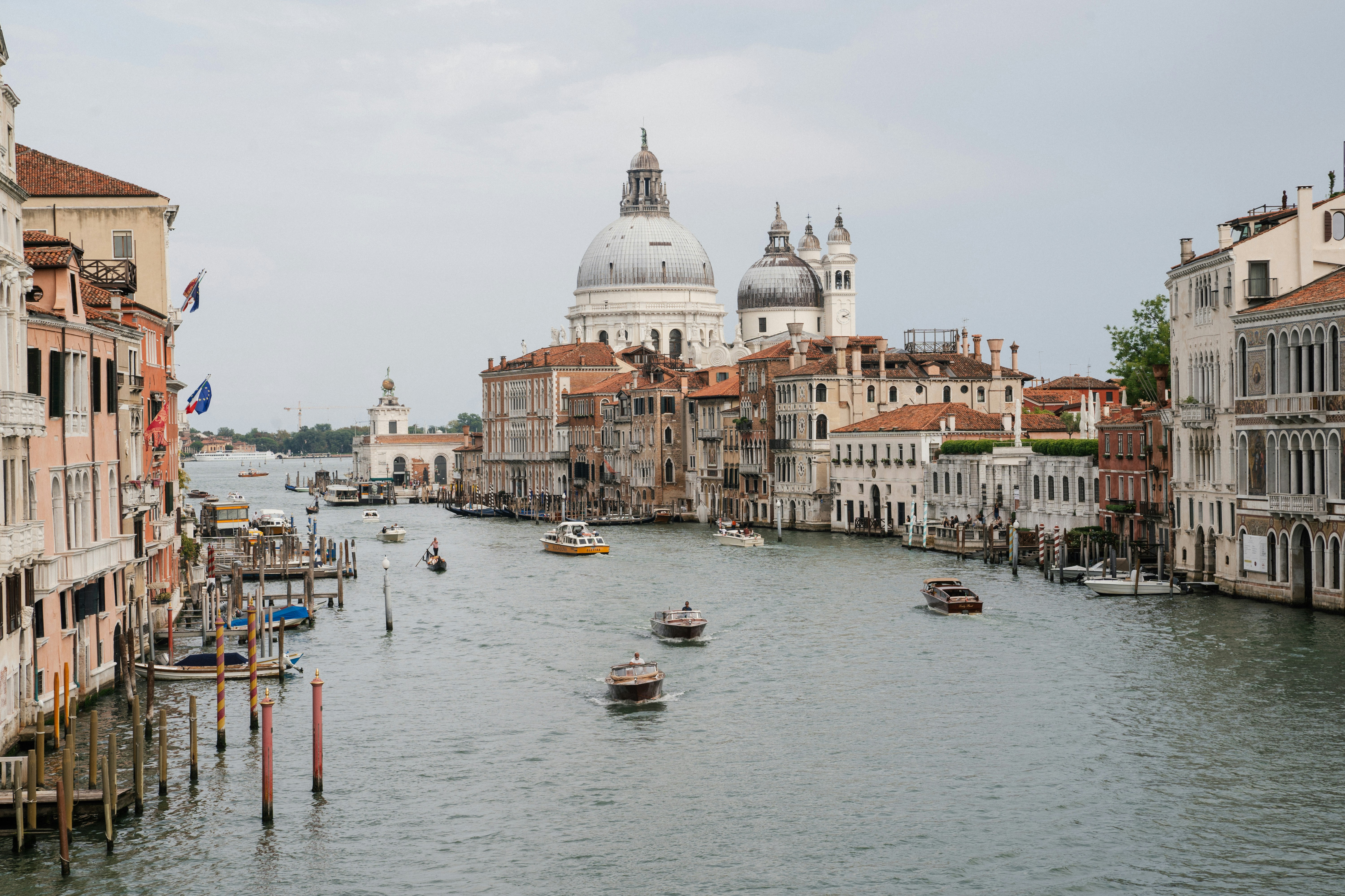 Boats navigate the grand canal in venice with historic buildings.