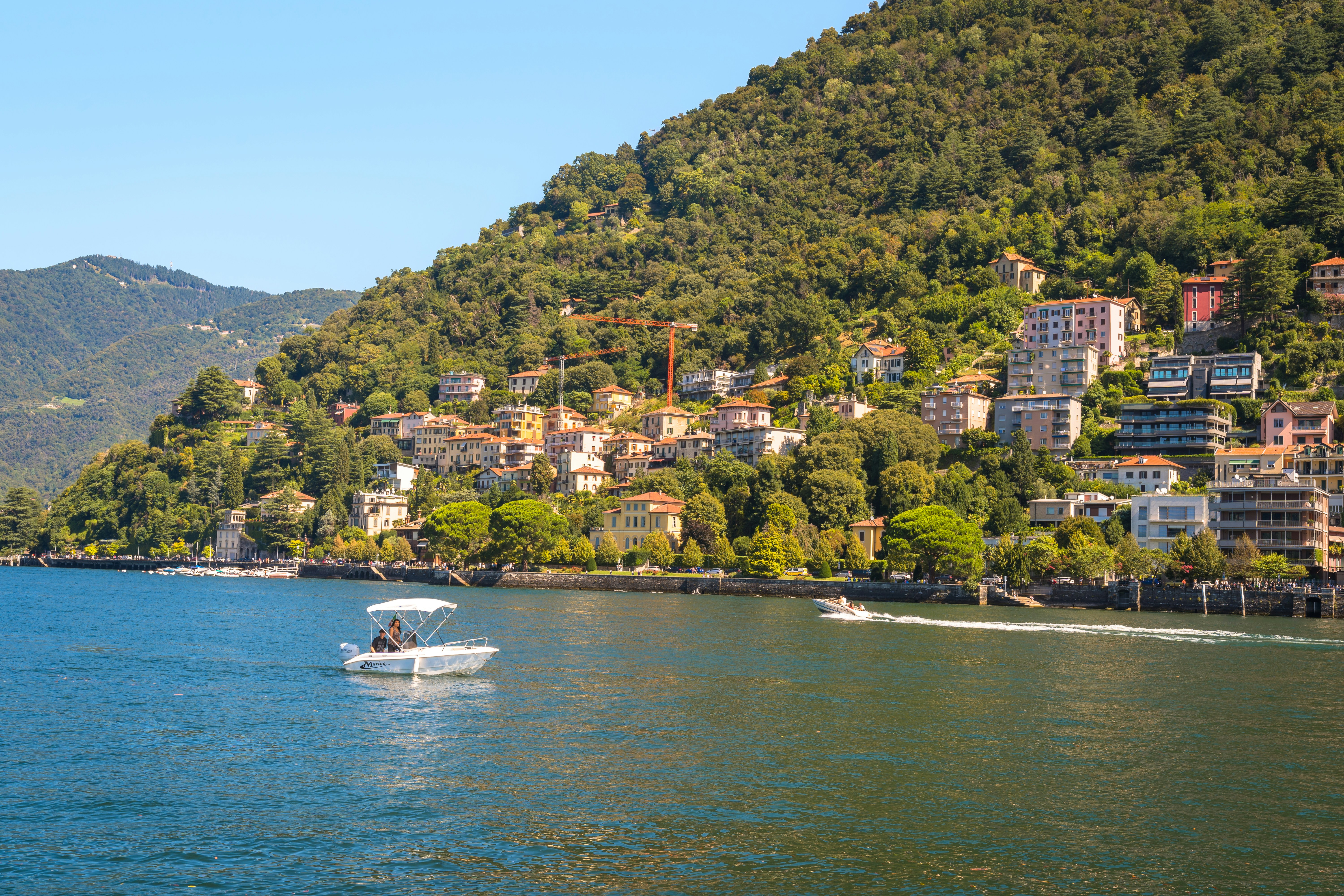Boats on a lake with a town on a hillside.