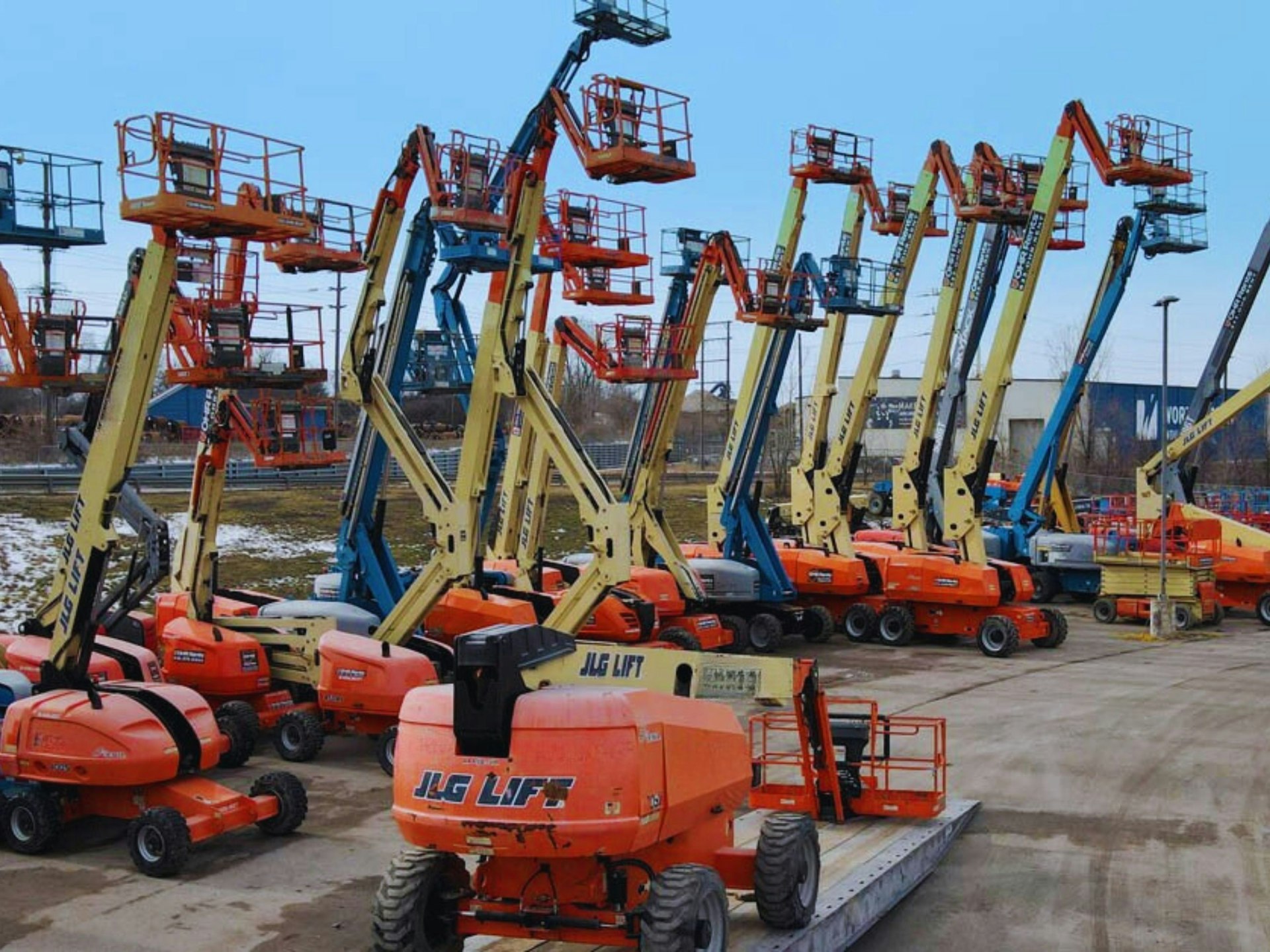 Fleet of boom lifts on an industrial yard